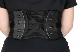 Pessoa utilizando cinto lombar ortopédico com hastes de suporte para estabilização da coluna e proteção da região lombar durante atividades físicas ou trabalho.