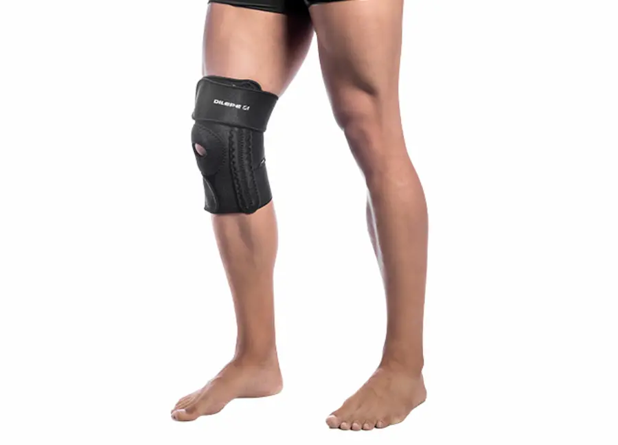 Pessoa utilizando joelheira ortopédica com suporte patelar para estabilização do joelho e proteção durante atividades físicas ou recuperação de lesões.